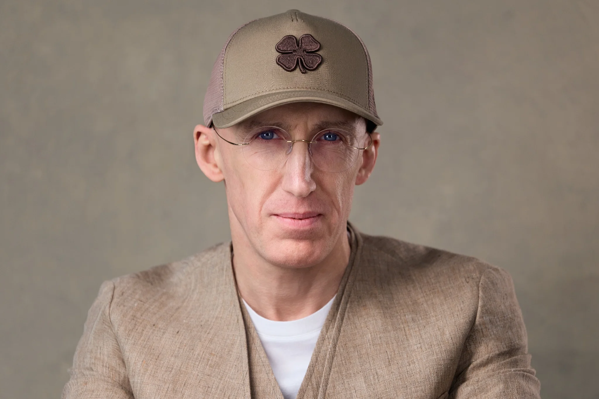 Close-up portrait of Soft2Bet founder Uri Poliavich wearing a beige cap and glasses
